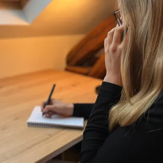 Valentine Soleau au téléphone, prenant des notes à son bureau